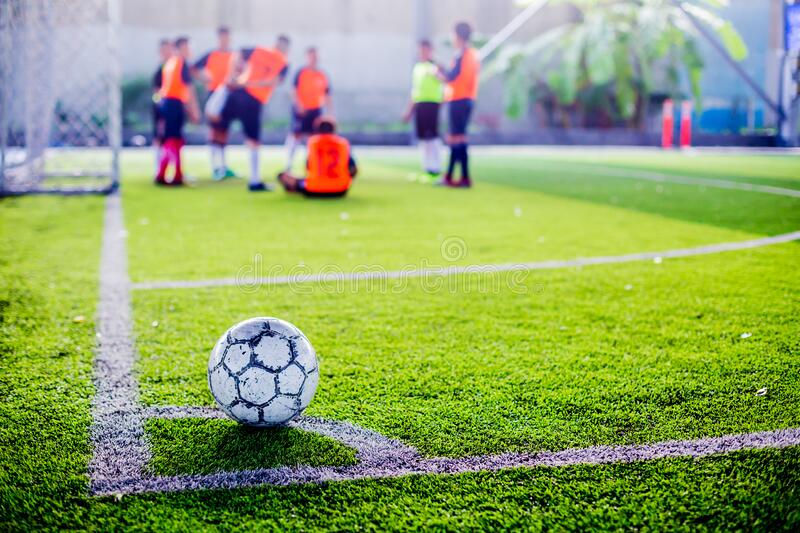 soccer ball green artificial turf corner football field blurry players background kick kid training match 175569686